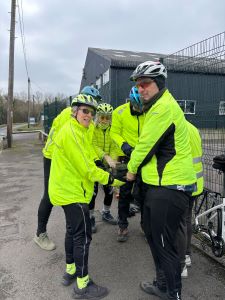 Several ECC members all holding one bicyc;e wheel