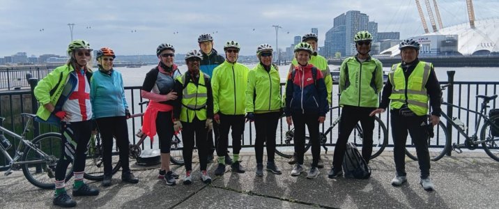 Group photo of riders at the riverside, with the Millenium Dome in the bacgground