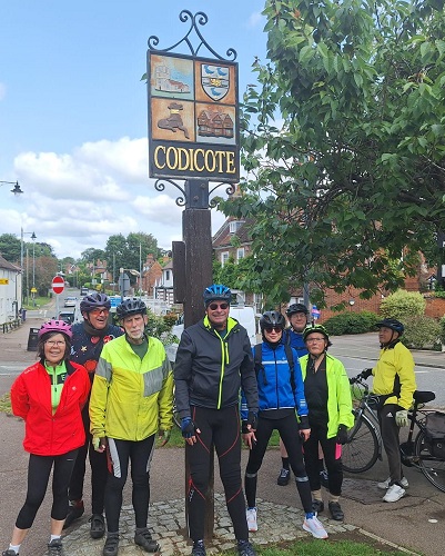 Riders standing around the Codicote village sign