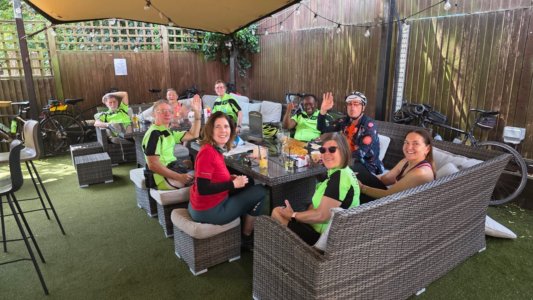 cyclists lounging in a marquee in a pub garden