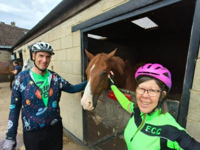 Two club members petting a horse in the stables