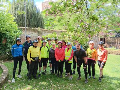 A group photo of all riders taken in the garden of Abigails Tea Rooms,  The cathederal tower can be glimpsed in the background